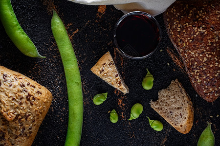 桌子的组成 由黑色和纹理化背景上的面包 豆类 葡萄酒和面粉组成 地中海饮食 开胃酒和健康烹饪白色豆子生活产品食物乡村小麦棕色美食背景图片
