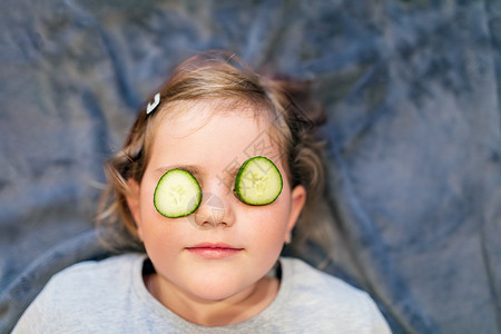 带黄瓜的小可爱女孩儿父母沙龙治疗眼睛童年孩子皮肤乐趣女儿妈妈背景图片