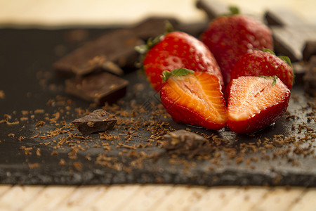 将草莓划在一块板板板上 并用切碎的chocola宏观糕点奶油糖果桌子食物小吃美食诱惑饮食背景图片