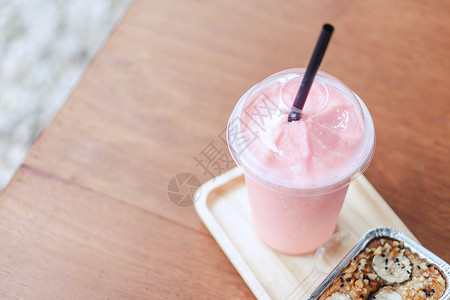 粉色果汁特写草莓冰淇淋和蛋糕 配绿色自然树枝牛奶稻草水果杯子甜点食物红色玻璃饮料咖啡店背景