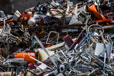 垃圾场的废铁碎金属丢弃蓝色废料回收废金属废料场红色背景图片