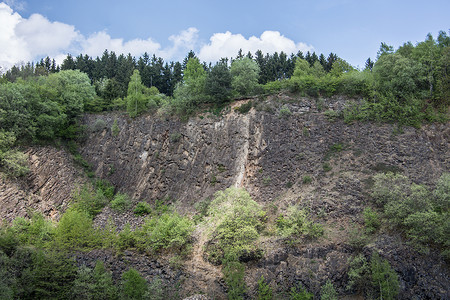 穿石坡湖山坡由湖边的拜萨尔特岩石制成表面绿色矿物质植物蓝色自然公园火山岩天空棕色树叶背景