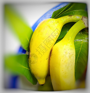 以碗和健康食品以及每日健康水果维他命C为包装 配有一些叶子的香蕉香蕉叶背景图片