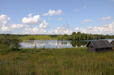 湖边的小澡堂爬坡房子铺板巨石草地草原管子画报蓝色天空背景图片
