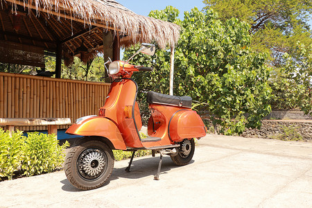 印度复古摩托车在巴厘的一条公共街道上停靠 2019年6月 印度尼西亚 普通摩托车轮和车身设计细节旅行发动机刹车城市运输黄蜂橙子摩托轮子自行车背景