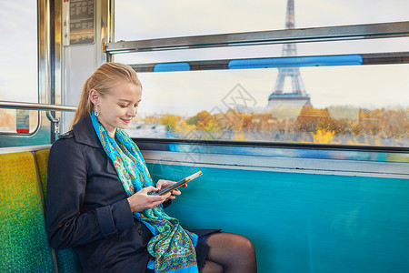 美丽的年轻女子乘坐巴黎地下的火车 阅读一本书 女主角运输城市工具窗户女士商业女孩游客乘客工作背景图片