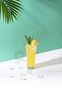 脚印杯子杯子里的冰菠萝鸡尾酒 在绿色背景上 夏季饮料背景