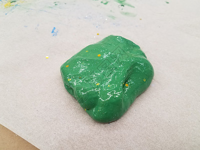 湿绿色粘液 蜡纸上有金亮光工艺乐趣金子黏土背景图片