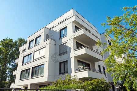 柏林现代豪华豪华公寓房市场奢华地面树木花园高楼土地蓝色建筑天空背景图片