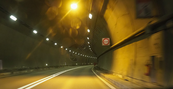 带有橙色灯光的公路隧道背景图片