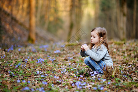 可爱的姑娘采摘春天第一朵花乐趣童年微笑女儿生活女性太阳公园肝病木头背景图片