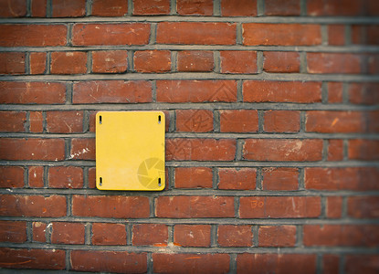 红砖墙上的英国旧白色黄黄色街牌背景图片