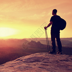 人手握着观光杆 在山谷上背负着运动背包极限悬崖姿势深谷远足者游客顶峰自由幸福射线背景图片