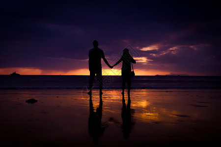 休渔期一对夫妇的休丽花 牵起彼此的手 欢乐的年轻情侣 在日落时在沙滩上相爱夫妻家庭阳光女性情人男人海洋海岸男性蜜月背景
