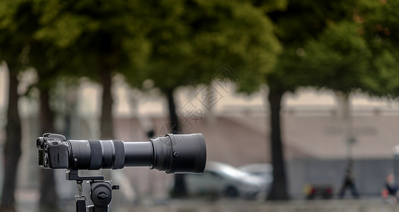 三脚架相机在故意模糊的背景下 安装了35毫米的三重摄像机 有长焦距长的大镜头镜片背景