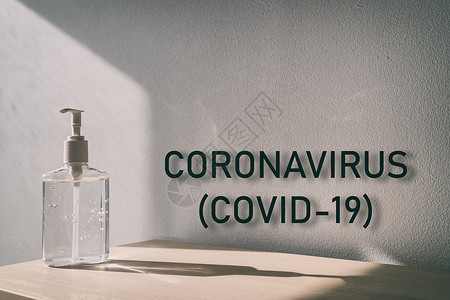 Coronna病毒(COVID-19) 在全球流行的冠状病毒爆发中带有手消毒剂瓶子背景的文本标志背景图片