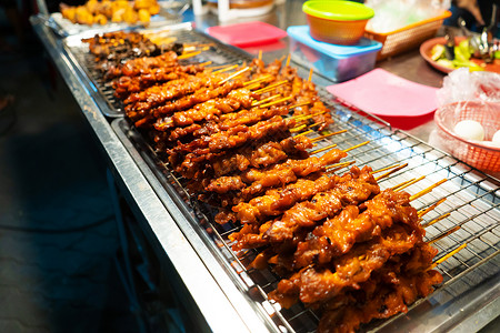 新加坡叻沙亚洲食品 在夜街食品市场用鸡皮和肉类小烤箱的柜台烧烤盘子小吃食物美食餐厅竹子炙烤沙爹烹饪背景