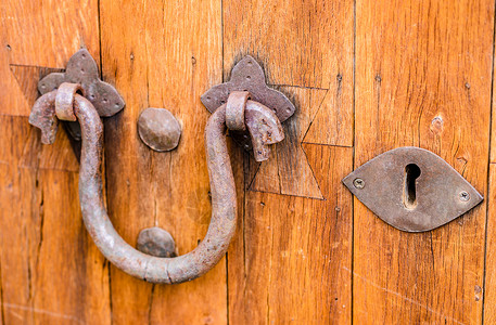 职场女性敲总经理室门Rusty 门敲锁器和旧木制门的钥匙孔背景