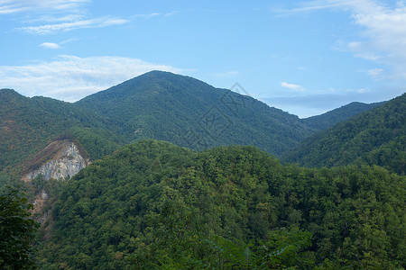 绿林山森林绿色山脉天空蓝色山峰丘陵岩石背景图片