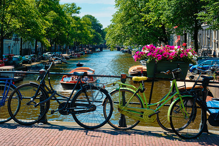 阿姆斯特丹运河 在桥上装有船只和自行车街道目的地旅游游客建筑学房子运输首都景点运河背景图片