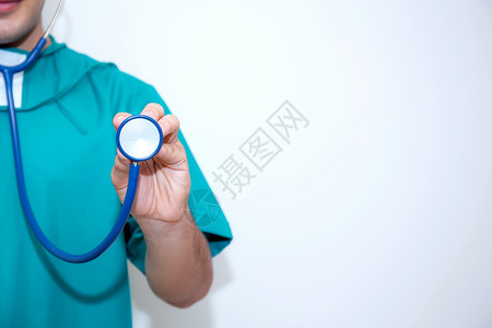 穿着绿色制服的男性医生 用白色背景隔离的听诊器闭合了伤口背景图片