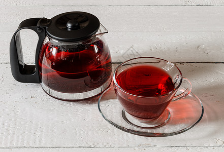 考卡德卡尔卡德红茶杯和木桌上的酒壶叶子草本杯子桌子药品花瓣白色盘子草本植物红色背景