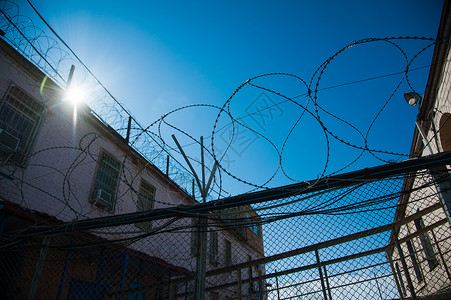 围在监狱围墙周围的栅栏犯罪细胞金属边界囚犯警卫障碍危险天空安全背景