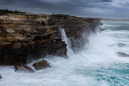 大巨浪冲撞悉尼的悬崖背景图片