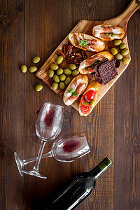 红酒和零食放在切割板顶视图上玻璃液体酒杯火腿饮料红色酒厂瓶子餐厅庆典背景图片