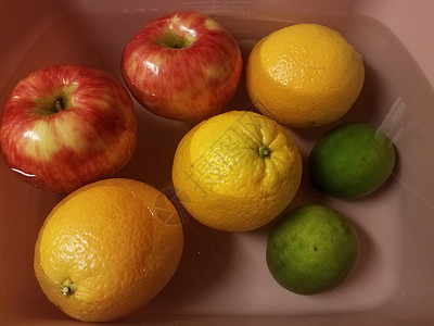 在水中漂浮的苹果 橙子和石灰浮力橘子打扫青柠小吃洗涤食物红色绿色背景图片