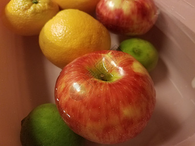在水中漂浮的苹果 橙子和石灰绿色青柠小吃橘子打扫食物红色洗涤浮力背景图片