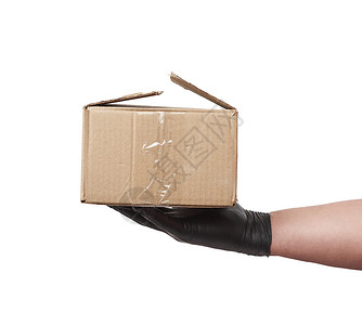 棕色手套黑乳胶手套上装着一盒棕色Kraftp p的纸箱运输工艺男性货物手指船运邮政包装品牌广告背景