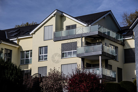 蓝色天空下斜坡上有共居公寓的房子背景图片