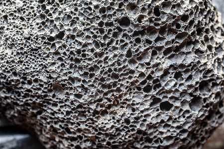海绵状的灰色多孔宝石作为火山发光岩石海绵状浮力浮石火山岩毛孔矿物学背景
