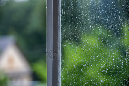 湿窗玻璃抽象背景与雨水下落 夏日绿色模糊背景与选择性聚焦和复制空间背景图片