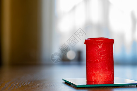 一张厚厚的红蜡烛站在桌子上 侧面视图喜庆木头食物温泉浪漫燃烧仪式房子圆柱形火焰背景图片