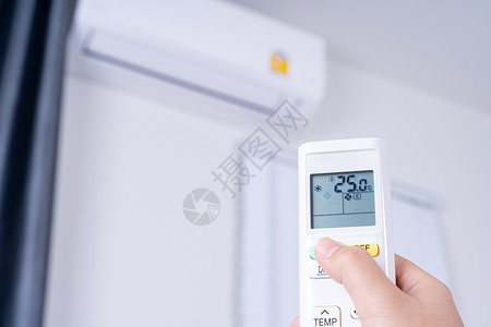 空调按钮人手正在使用空调的白色遥控器打开或调节室内空调的温度展示控制技术气候空气呼吸机活力状况冷却器冷却背景