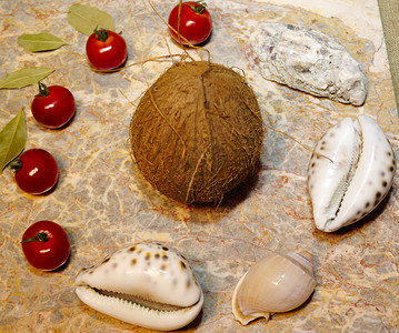 大理石表面上的蔬菜 贝壳和椰子 圣女果 辣椒 月桂叶 牡蛎 贝壳和椰子背景图片
