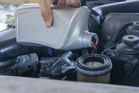 汽车换机油负责汽车服务和维修保养的机械工紧握手 更换新的液压油换机背景