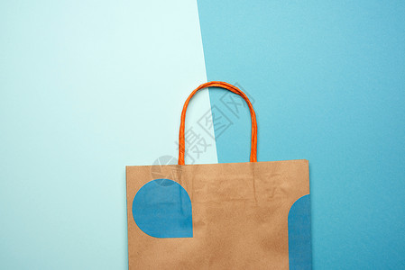 棕色纸袋 上面有蓝色背景的购物手柄背景图片