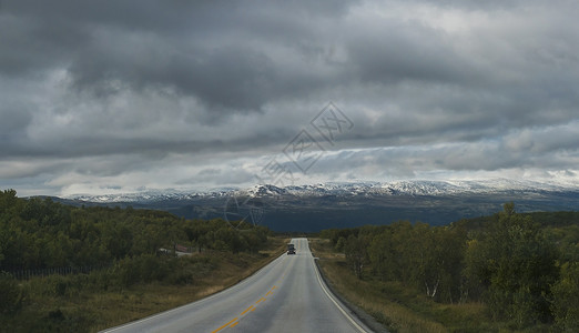 奥普兰从挪威 E6 主干道出发 在自然公园蜿蜒的道路上欣赏山丘和白雪皑皑的山脉和壮观的云彩戏剧性旅行荒野项目缠绕蓝色开发曲线云景远足背景