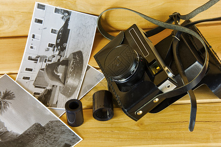 旧胶片照相机 有木制表面的封面 照片和胶片背景图片