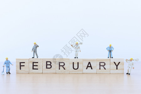 工人玩具二月的话语 与迷你人工人正方形数字木头立方体工人桌子玩具日历背景