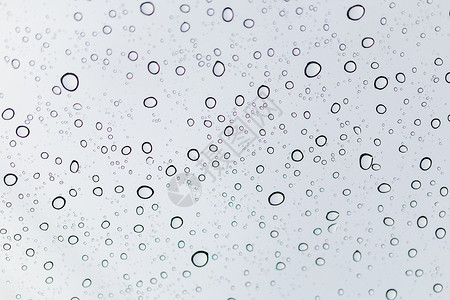 窗口眼镜表面的雨滴水滴天空液体灰色天气玻璃水分窗户白色背景图片