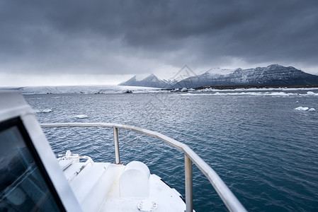 船冰山环礁湖上的两栖船只冰山海洋渔业支撑天空两栖动物旅行冻结钓鱼峡湾背景