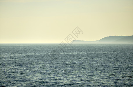 位于中间的小岛屿海岸天气太阳地平线天空阳光海景海浪假期海洋背景图片