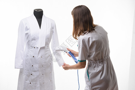身着医疗服装的女孩用修指甲处理蒸汽衣服背景图片