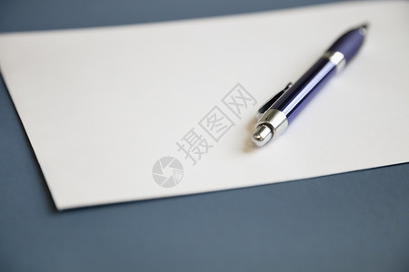 黑蓝背景的空白白纸上的金属笔 O组织书写纸质工具文档焦点前景静物材料白色背景图片