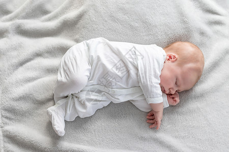 产褥期新生男孩睡在毯子上的顶端景色背景