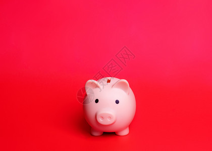 粉红小猪银行在红色背景下被孤立背景图片